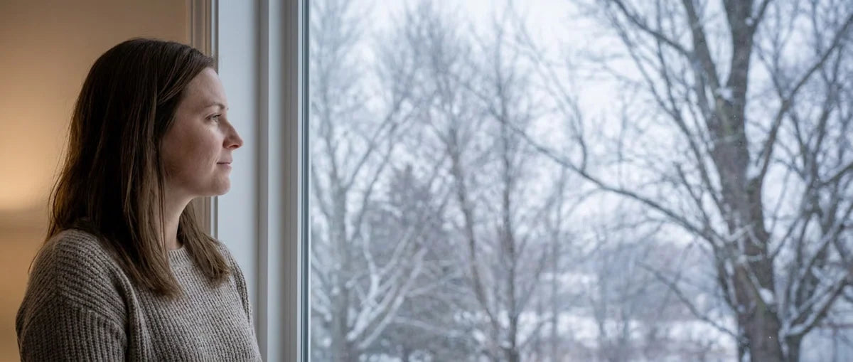 A woman looking out at a winter morning.